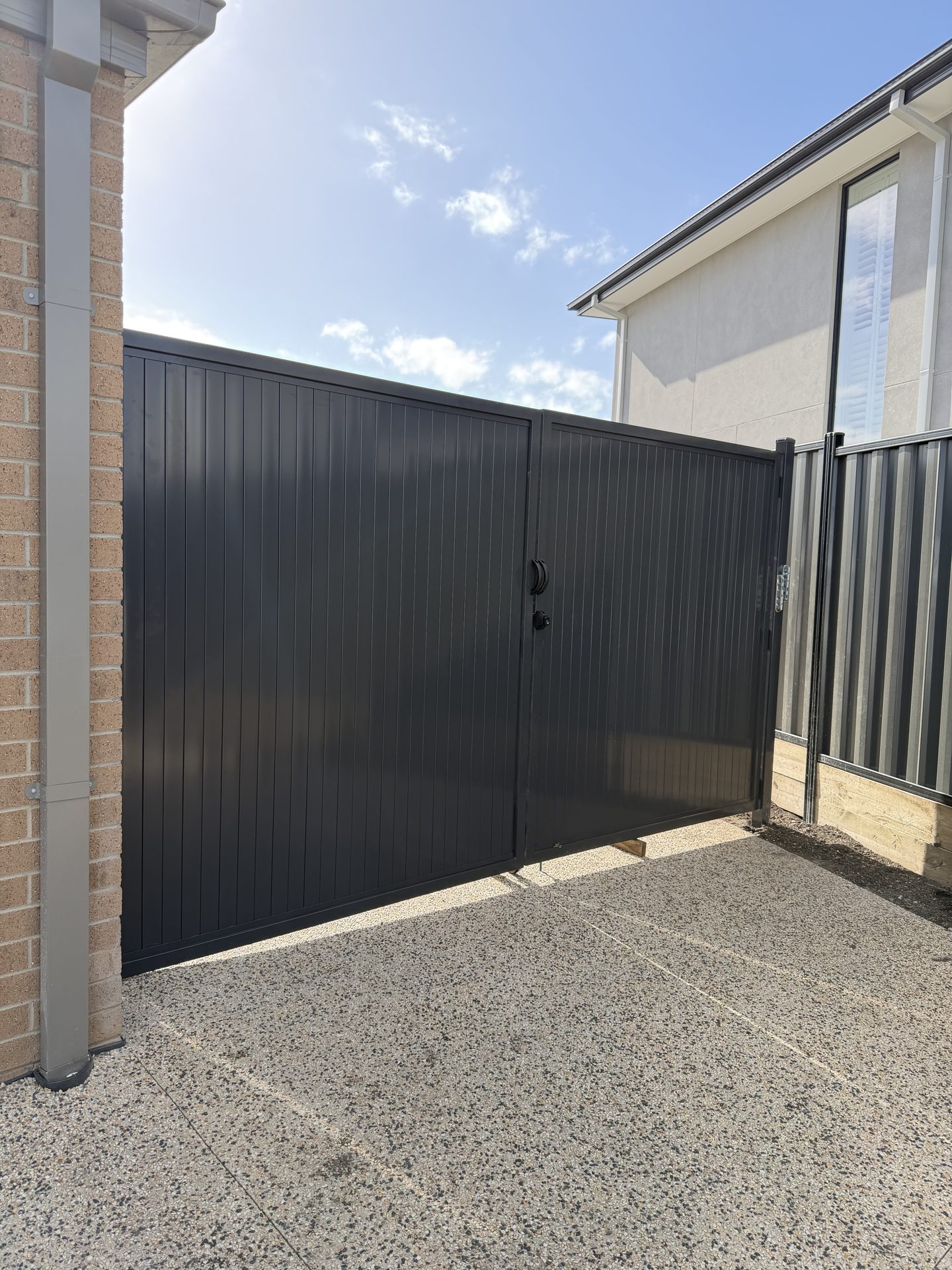 Black vertical-slat aluminium double gate installed in Melbourne