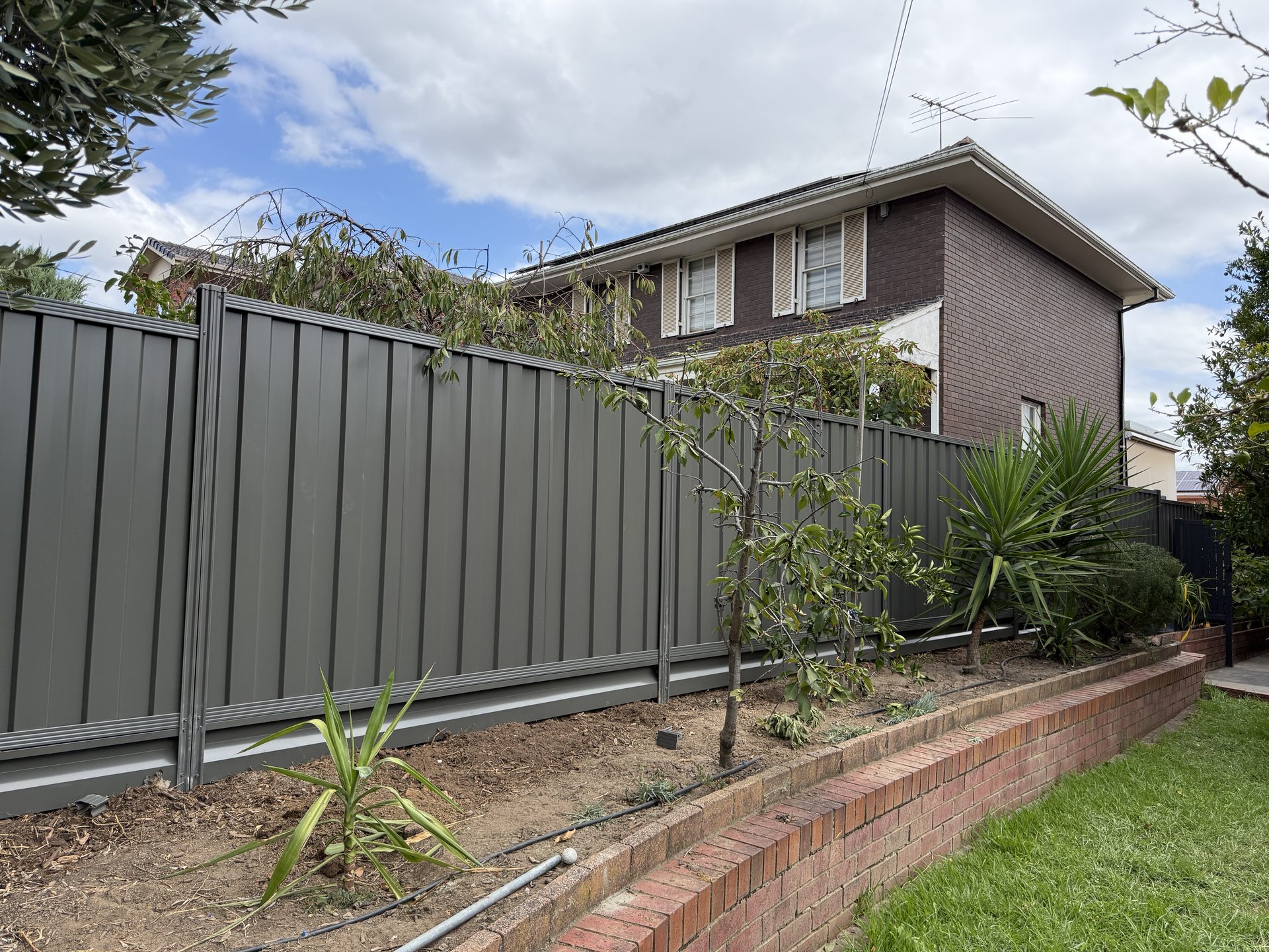 Dark grey Colorbond fence on timber plinth, Melbourne