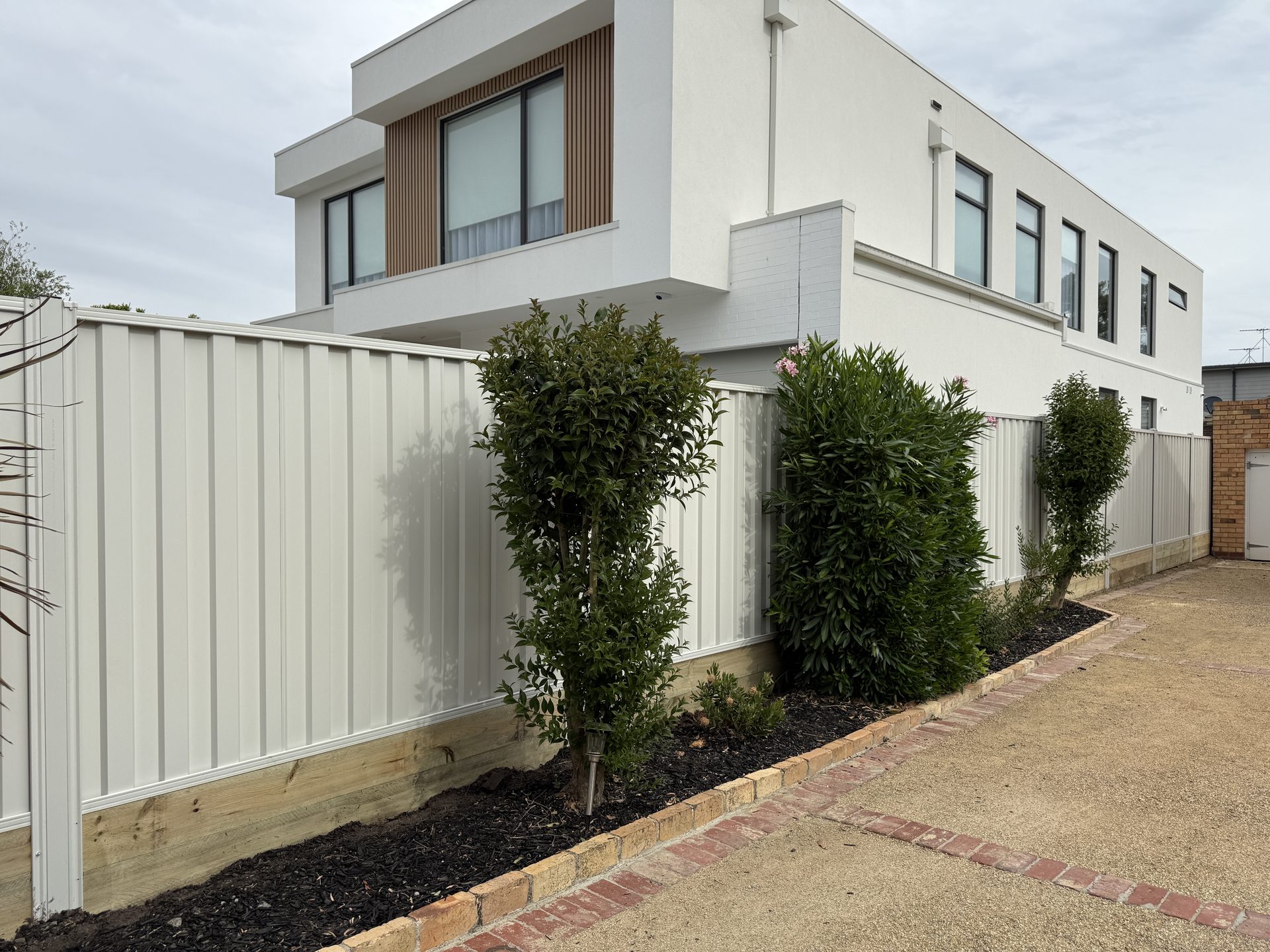 Cream Colorbond fence, modern home — Melbourne