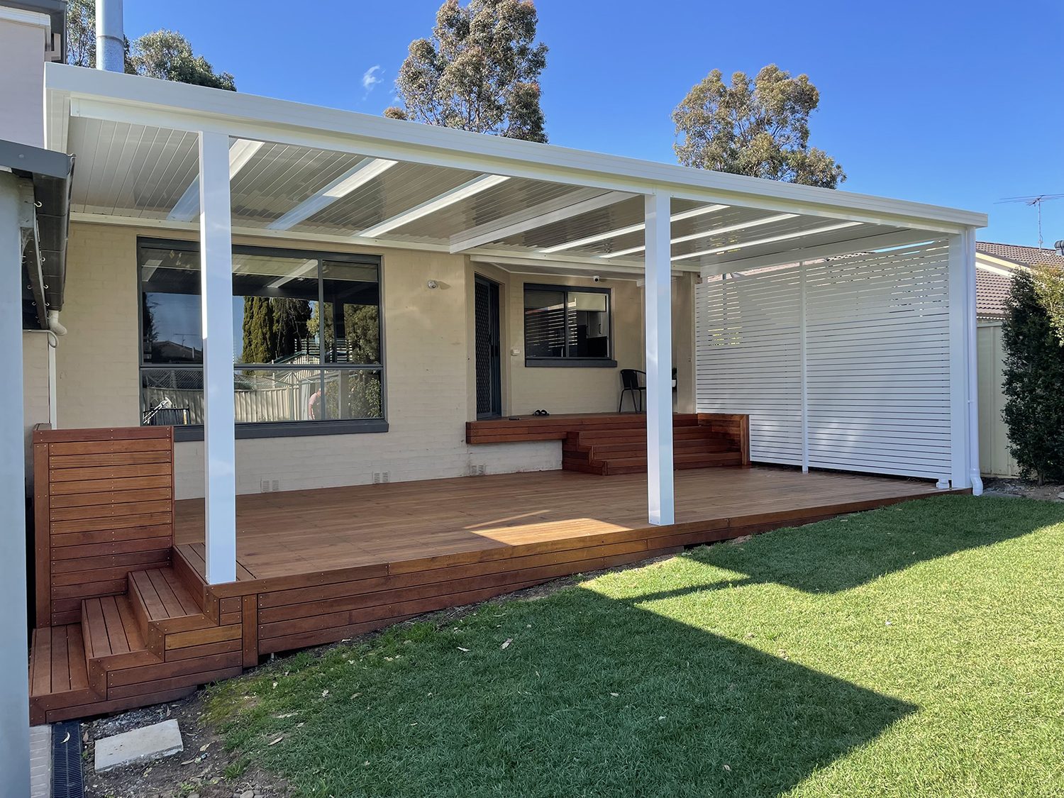 White flat-roof pergola with privacy screen and deck, Melbourne