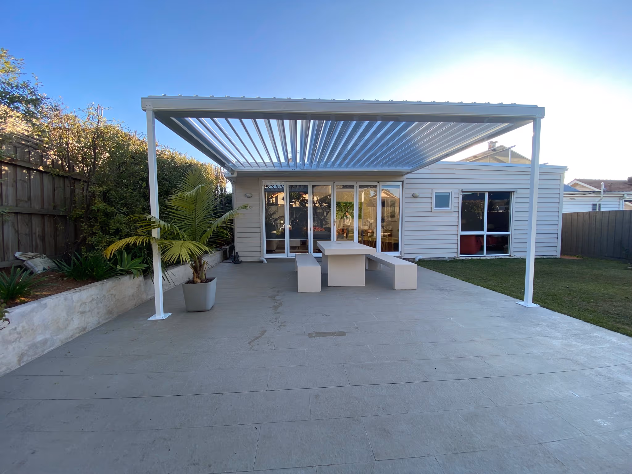 Louvre roof pergola over a paved outdoor entertaining area